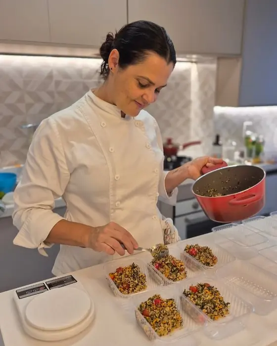 Elisabete montando as refeições porcionadas na bancada