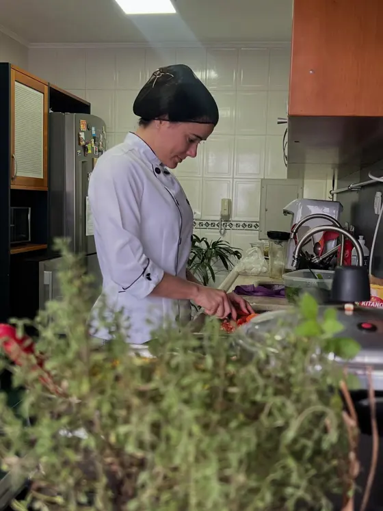 Nutricionista em mentoria cozinhando, com a Elisabete ao fundo