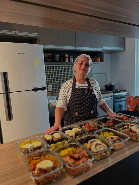 Aluna de mentoria na cozinha, com a semana inteira de refeições montada à frente