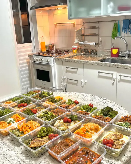 Bancada da cozinha com dezenas de marmitas montadas